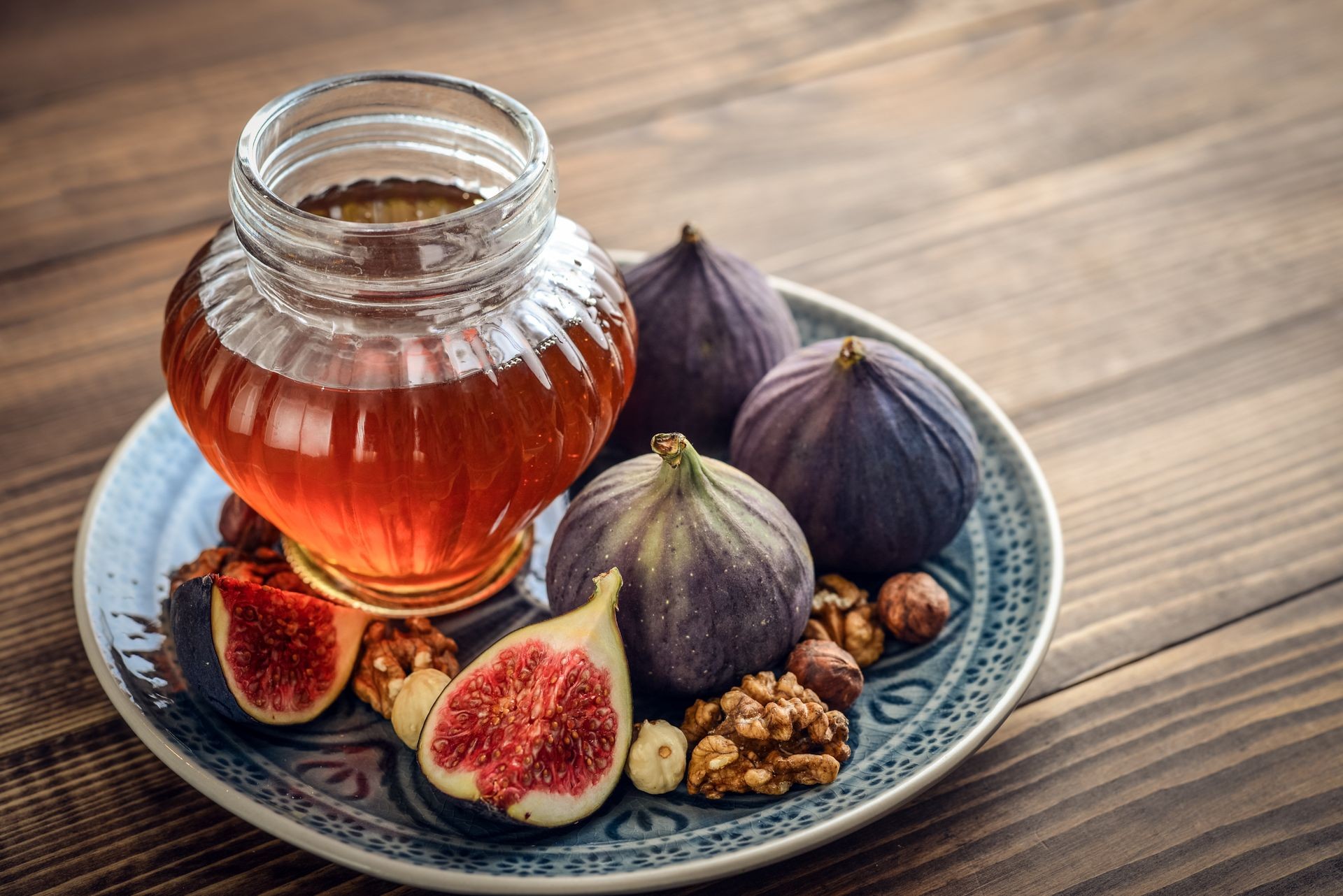 Greek Honey with fresh figs and nuts on wooden background closeup